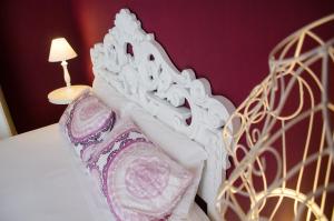 a close up of a white bed with a lamp at Hotel Silva in Alberobello