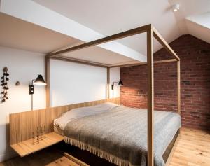 een slaapkamer met een bed en een bakstenen muur bij Apartamenty Rynek 10 in Bielsko-Biala