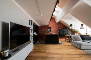 a living room with a large television and a couch at Apartamenty Rynek 10 in Bielsko-Biała