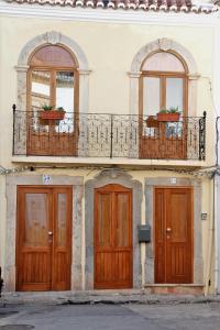 een gebouw met drie deuren en een balkon bij Casa Amarela in Tavira