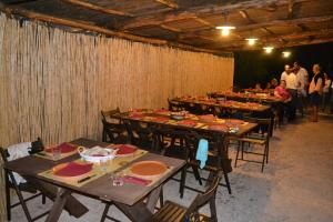a group of tables in a room with people standing around at Agriturismo La Torre Rossa in Itri