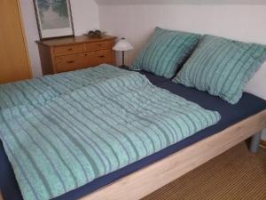 a bed with a blue comforter and a dresser at Altstadt-Apartment Petershagen in Petershagen