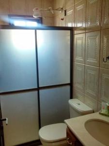 a bathroom with a white toilet and a sink at Apartamento de temporada in Rio das Ostras