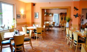 a restaurant with tables and chairs in a room at Restaurant & Pension Storchenklause in Storkow