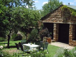 a table and chairs in front of a stone building at Bethel Lodge in Clarens