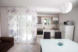een keuken met een tafel en een keuken met een tafel en stoelen bij Apartment Green Oasis in Split