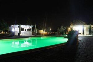 una piscina por la noche con una caravana en el fondo en Agriturismo Zio Zac, en Torre Pali