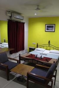 um quarto com duas camas e uma mesa e cadeiras em Deccan Comforts em Hyderabad