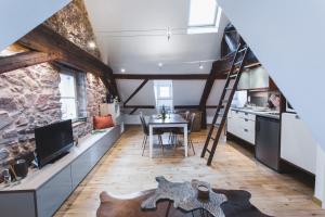 una cucina e una sala da pranzo in stile loft con scala; di Hissla Riquewihr Apartments a Riquewihr