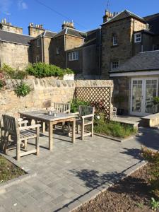 un patio con mesa y 2 sillas en No 5 Pilmour, en St Andrews