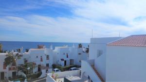 - une vue sur certains bâtiments blancs et l'océan dans l'établissement Apartamento de Praia - Albufeira, à Albufeira