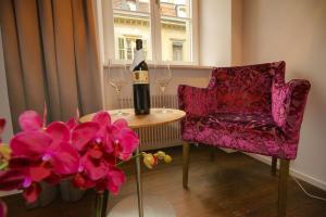 una botella de vino en una mesa con una silla y flores en Boutique Hotel - Restaurant Orchidee en Burgdorf