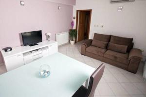 a living room with a white table and a couch at Apartment Green Oasis in Split