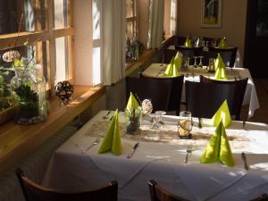 une rangée de tables dans un restaurant avec des serviettes jaunes dans l'établissement Gasthaus Metzgerei Pension Maßem, à Schillingen