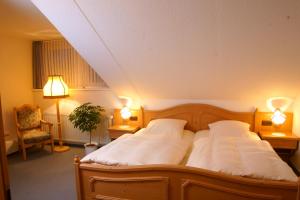 a bedroom with a bed with two white pillows at Röhrs Gasthof in Sottrum