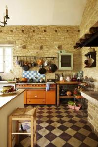 eine Küche mit einem karierten Boden und eine Küche mit einem Herd in der Unterkunft La Demeure du Figuier in Évran