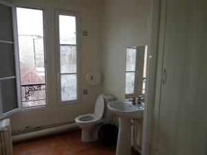 baño con aseo y lavabo y ventana en Au Royal Mad, en París