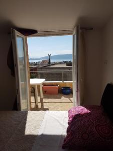 una camera da letto con porta che si apre su un balcone con vista di Apartment Dijana a Kaštela (Castelli)