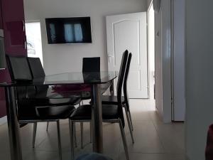 a dining room with a glass table and black chairs at Apartment Dijana in Kaštela