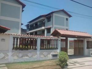 a house with a fence in front of it at Apartamento de temporada in Rio das Ostras