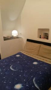 サンレモにあるElegante Loft Nel Cuore Di Sanremoのベッドルーム1室(青い掛け布団、ランプ付)