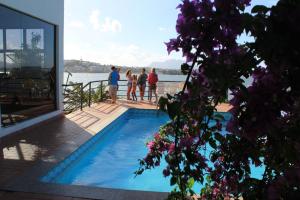 a group of people standing next to a swimming pool at Hospedagem Sol e Mar in Vila Velha