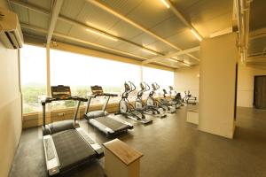a gym with rows of treadmills and a large window at Downtown Business Hotel in Singapperumālkovil