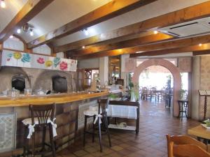 un restaurante con bar y algunas mesas y sillas en Hotel Las Casitas en Boceguillas