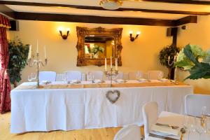 a room with a table with white chairs and a mirror at The Roundabout Hotel in Pulborough