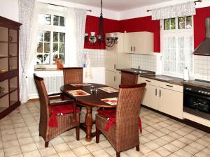 バート・ピルモントにあるWeser Uplands Retreatの赤い壁のキッチン(テーブル、椅子付)