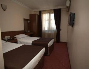 a hotel room with two beds and a window at Lyon Hotel İstanbul in Istanbul