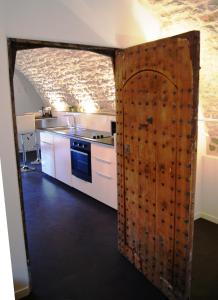 a kitchen with a wooden door in a room at De Pierre et de Lumière in Jouhe