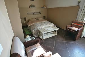 a bedroom with a bed and a couch and chairs at La Bastide des Sources in Le Castellet