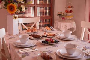 una mesa con platos y tazas y comida en ella en Cento Passi dal Duomo B&B, en Arezzo