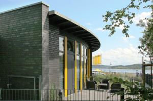 ein Gebäude mit gelben Türen und Stühlen auf einer Terrasse in der Unterkunft ADAC Campingplatz in Möhnesee