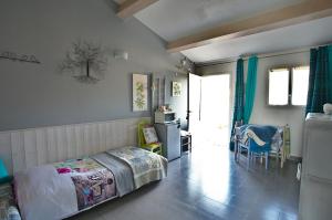 a bedroom with a bed and a table and a kitchen at La Bastide des Sources in Le Castellet