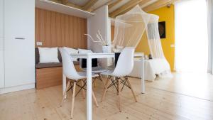 ein Esszimmer mit einem weißen Tisch und weißen Stühlen in der Unterkunft Ecosuite & SPA in Mailand