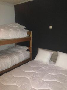 a bedroom with two bunk beds with white sheets at James D in De Haan