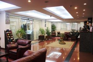 un vestíbulo con muebles de cuero y plantas en un edificio en Kadikoy Otel, en Estambul