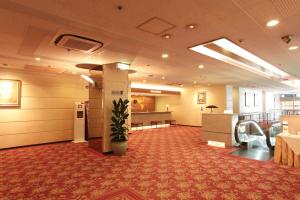 a lobby with a waiting room with a potted plant at Daiichi Inn Ikebukuro in Tokyo