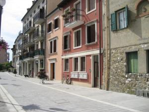 an empty street with buildings and a dog on a bike at Villa Gradenigo in Grado