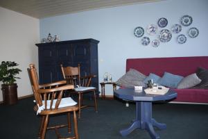 a living room with a couch and a table and chairs at Logerenbijonsz in Berghem
