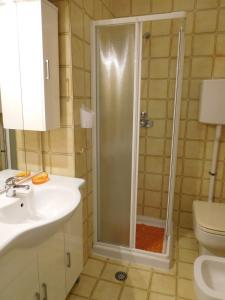 a bathroom with a shower and a sink and a toilet at Appartamento Saturnia in Grado +27 photos