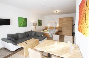 ein Wohnzimmer mit einem Sofa und einem Tisch in der Unterkunft GRÜNBLAU RELAX Pension & Apartments in Warnemünde