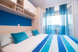a bedroom with a large bed with blue and white pillows at Marli - Split in Split