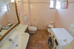 a bathroom with a sink and a washing machine in it at Casa del Sole in Finale Ligure