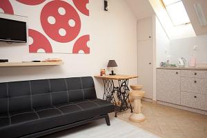 a living room with a black couch and a table at Katarzynka in Boleścin