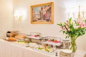 ローマにあるRaeli Hotel Archimedeのテーブルの上に数品の料理を揃えたビュッフェ