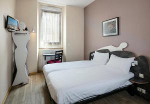 a bedroom with a white bed and a desk at L'Esterel in Cannes
