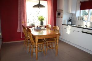 a kitchen with a wooden dining table and chairs at Logerenbijonsz in Berghem